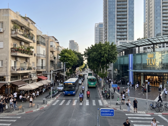 מבט רחוב על החשמונאים בתל אביב המציג אדריכלות מקומית ותנועה עירונית שוקקת.